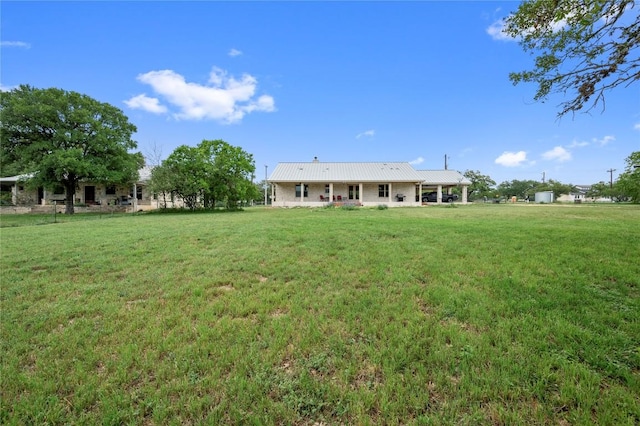 exterior space with metal roof and a front yard