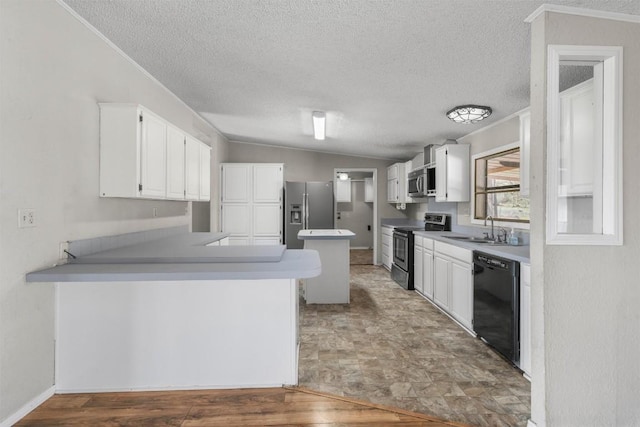 kitchen with a sink, ornamental molding, vaulted ceiling, white cabinets, and stainless steel appliances