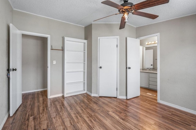 172 Hershal Ln, Cedar Creek, TX 78612 - unfurnished bedroom featuring crown molding, a textured ceiling, wood finished floors, connected bathroom, and ceiling fan