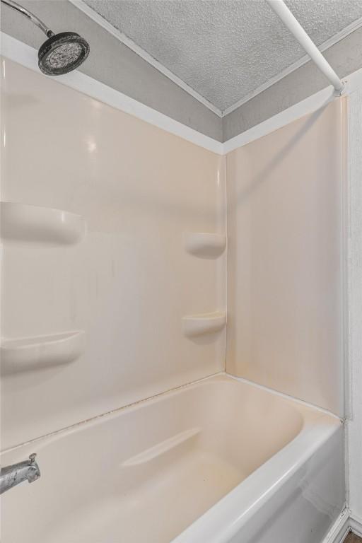 172 Hershal Ln, Cedar Creek, TX 78612 - bathroom with a textured ceiling and tub / shower combination