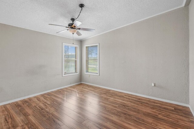 spare room featuring crown molding, ceiling fan, wood finished floors, a textured wall, and a textured ceiling