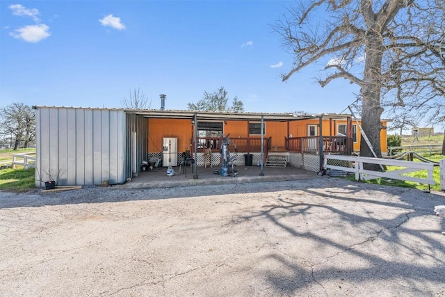 rear view of property featuring an exterior structure and an outdoor structure