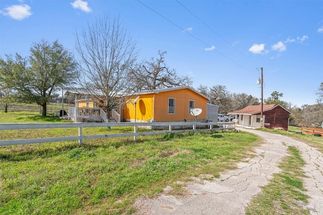 view of front of house with driveway and fence