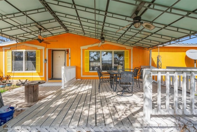 wooden deck with outdoor dining area and a ceiling fan