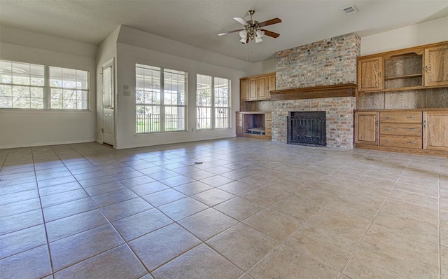 unfurnished living room featuring visible vents, a ceiling fan, light tile patterned flooring, a fireplace, and baseboards