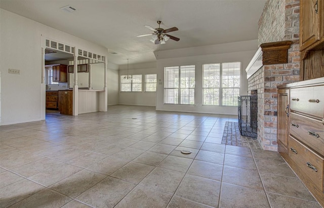 unfurnished living room with baseboards, visible vents, light tile patterned flooring, ceiling fan, and a brick fireplace