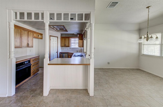 kitchen with visible vents, brown cabinets, black oven, a peninsula, and dishwasher