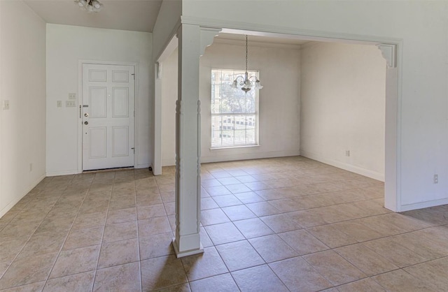 entryway with light tile patterned floors, decorative columns, baseboards, and an inviting chandelier