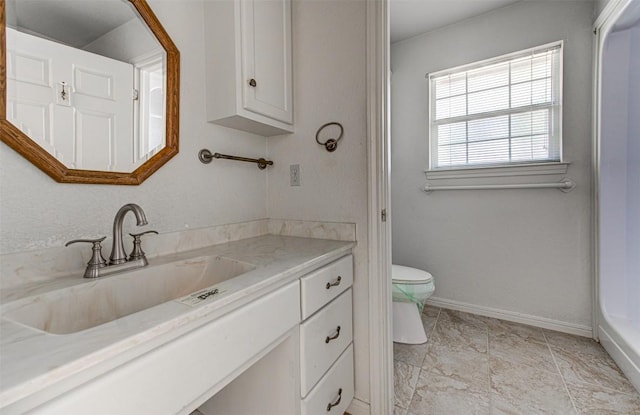 bathroom featuring vanity, toilet, and baseboards