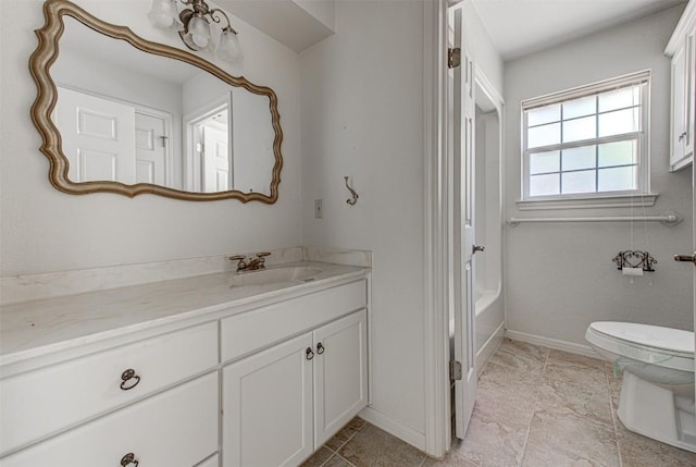 bathroom featuring baseboards, toilet, and vanity