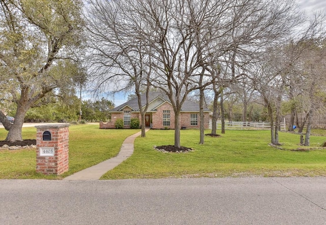 ranch-style house with a front lawn, fence, and brick siding