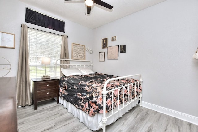 bedroom with wood finished floors, baseboards, and ceiling fan