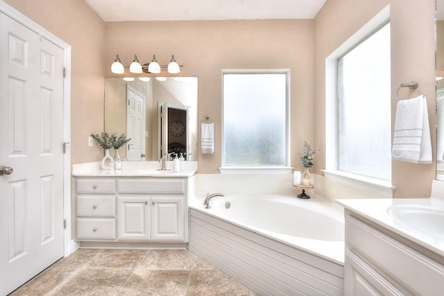 full bathroom featuring a sink, two vanities, and a bath