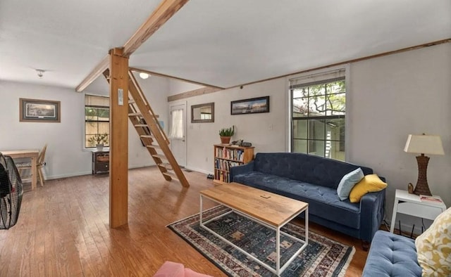 living room with stairs, a healthy amount of sunlight, baseboards, and wood-type flooring