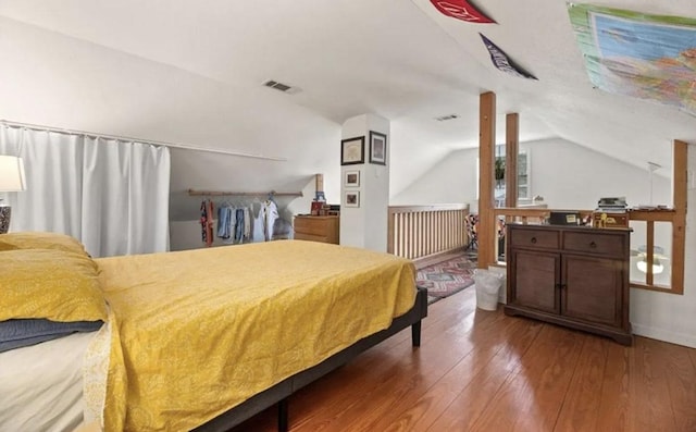 bedroom featuring visible vents, wood-type flooring, and lofted ceiling