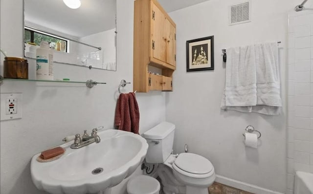 full bath with visible vents, baseboards, toilet, shower / bath combination, and a sink