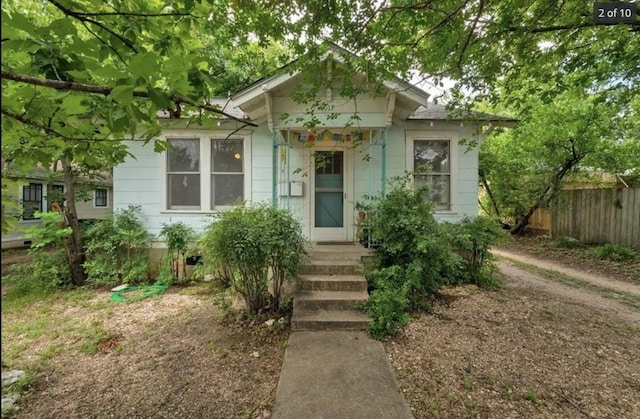 bungalow-style home with fence