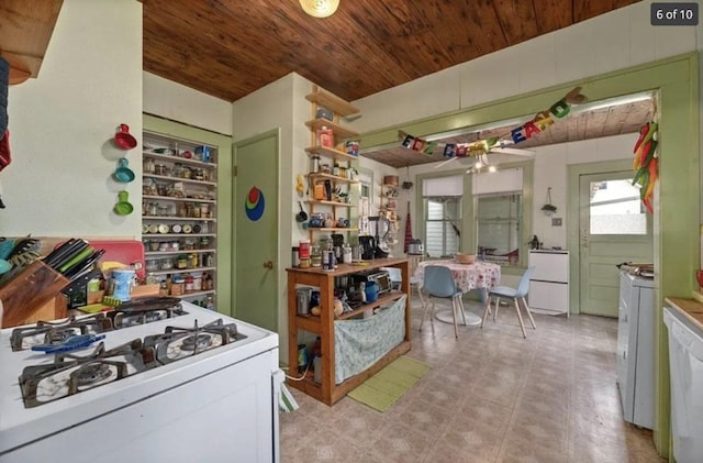 kitchen with white appliances, washing machine and dryer, wood ceiling, and light floors