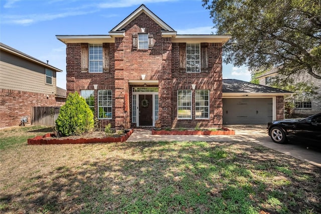 traditional-style house with brick siding, driveway, a front yard, and a garage