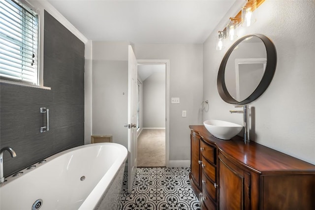 bathroom featuring tile patterned floors, vanity, baseboards, and a whirlpool tub