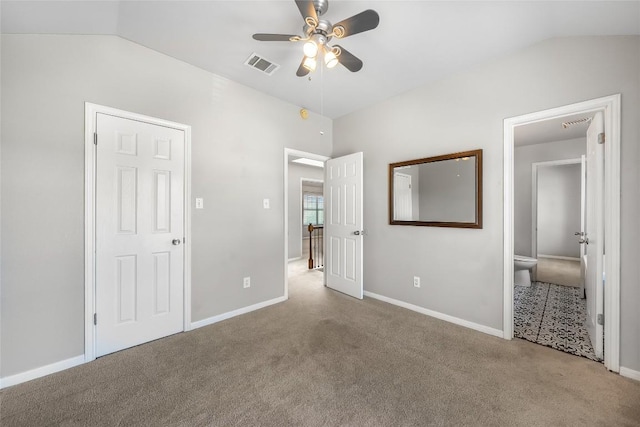 unfurnished bedroom featuring visible vents, baseboards, carpet, and lofted ceiling