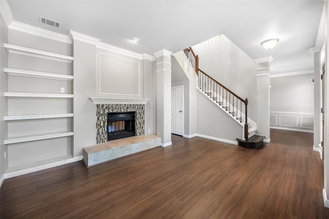 unfurnished living room featuring stairway, built in features, wood finished floors, visible vents, and crown molding