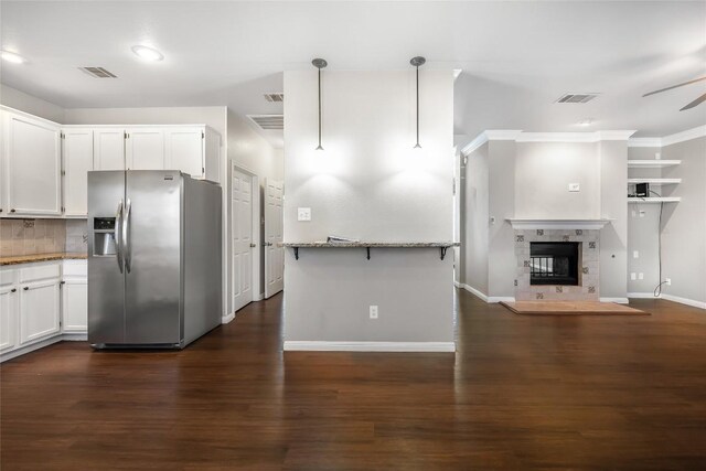 16901 W Stockton Dr, Leander, TX 78641 - kitchen with stainless steel fridge with ice dispenser, light stone counters, ceiling fan, dark wood-type flooring, and white cabinetry