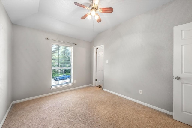 empty room with baseboards, light carpet, lofted ceiling, and a ceiling fan