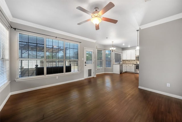 unfurnished living room featuring baseboards, dark wood-type flooring, ornamental molding, and ceiling fan with notable chandelier