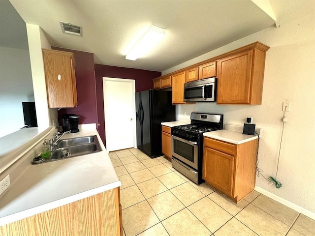 kitchen with a sink, visible vents, appliances with stainless steel finishes, and light countertops