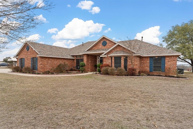 ranch-style house with brick siding, a shingled roof, and a front lawn