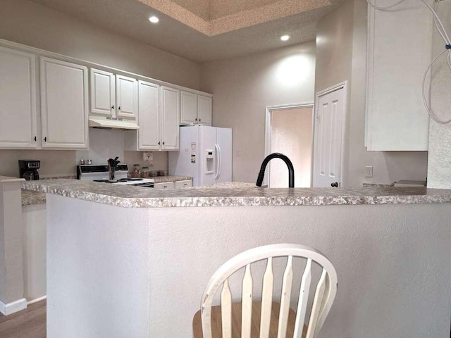 kitchen with under cabinet range hood, white appliances, white cabinets, and a sink