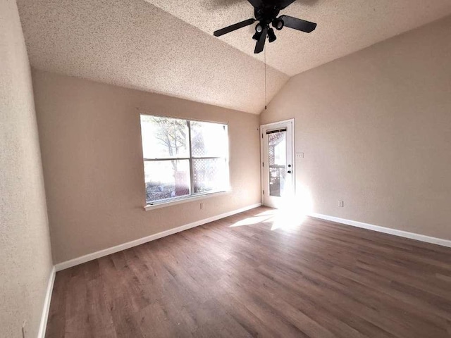 spare room with ceiling fan, baseboards, lofted ceiling, wood finished floors, and a textured ceiling