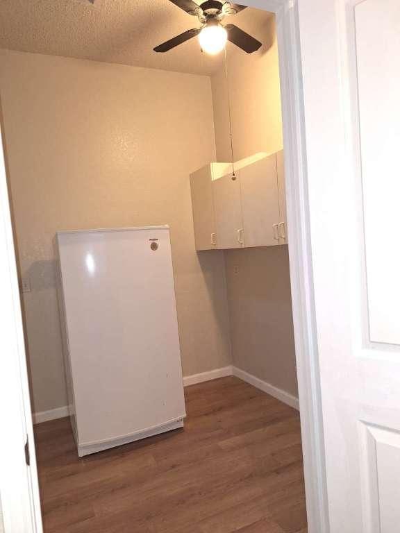 walk in closet with wood finished floors and ceiling fan