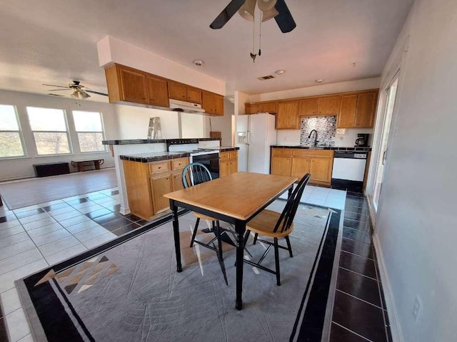 dining space featuring visible vents, baseboards, dark tile patterned floors, and a ceiling fan