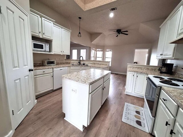 107 Patricia Rd, Georgetown, TX 78628 - kitchen with white appliances, a peninsula, a textured ceiling, ceiling fan, and white cabinets