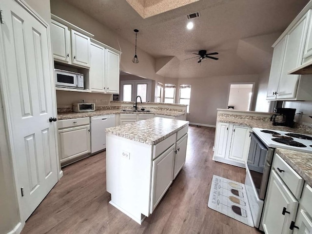 107 Patricia Rd, Georgetown, TX 78628 - kitchen featuring white appliances, a peninsula, a textured ceiling, ceiling fan, and white cabinetry