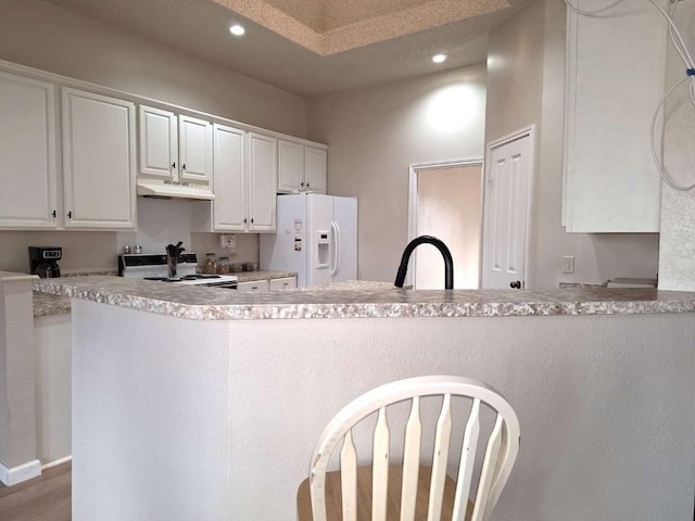 107 Patricia Rd, Georgetown, TX 78628 - kitchen with white appliances, under cabinet range hood, white cabinetry, recessed lighting, and light countertops
