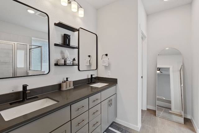 bathroom featuring a sink, a stall shower, double vanity, and tile patterned floors