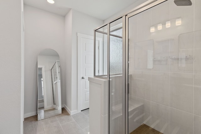 bathroom with baseboards, a stall shower, and tile patterned flooring