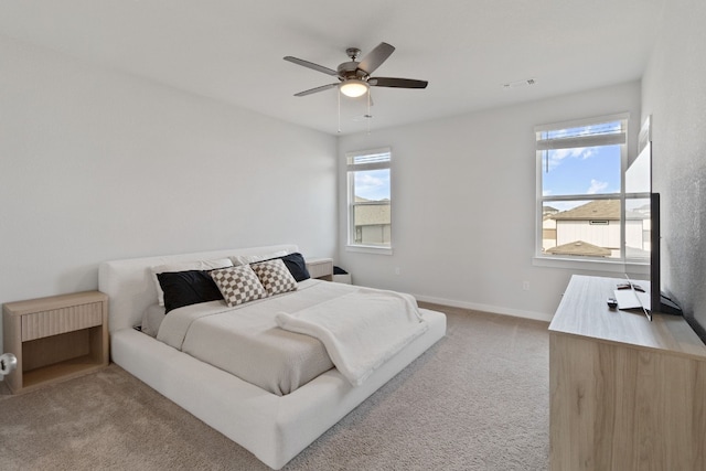 bedroom featuring light carpet, visible vents, baseboards, and ceiling fan