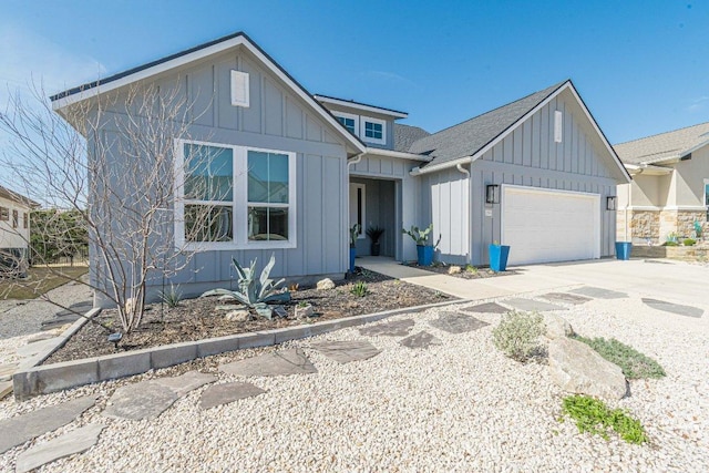 view of front of house featuring board and batten siding, concrete driveway, a garage, and roof with shingles