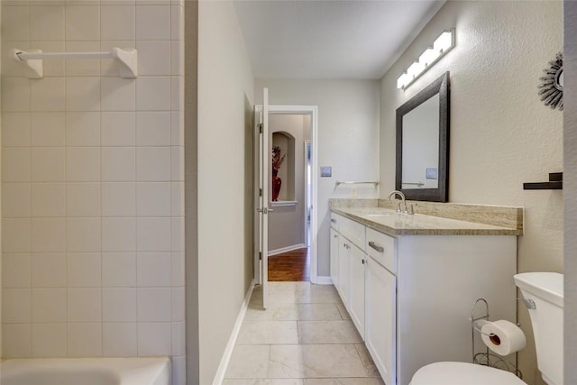 bathroom with baseboards, toilet, and vanity