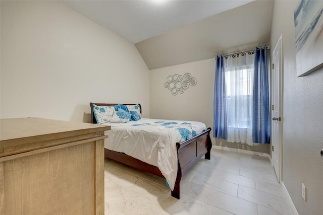 bedroom with vaulted ceiling and baseboards