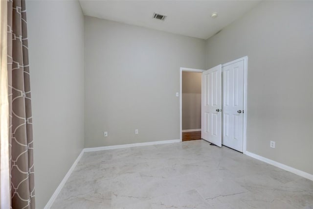 empty room featuring visible vents, marble finish floor, and baseboards