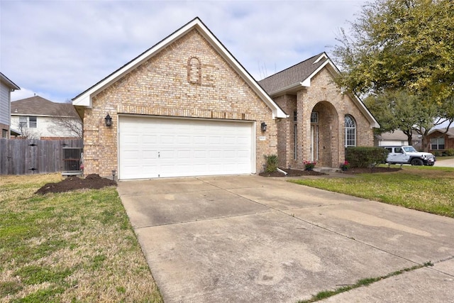 view of front of house with brick siding, a front lawn, fence, concrete driveway, and an attached garage