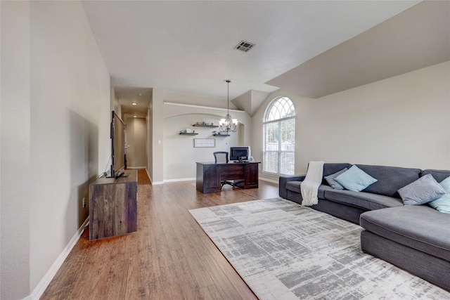 living room with visible vents, baseboards, lofted ceiling, wood finished floors, and a notable chandelier