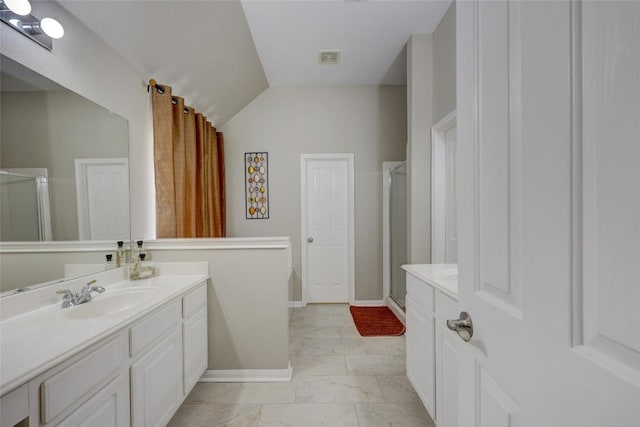 bathroom featuring a shower stall, vanity, baseboards, and vaulted ceiling