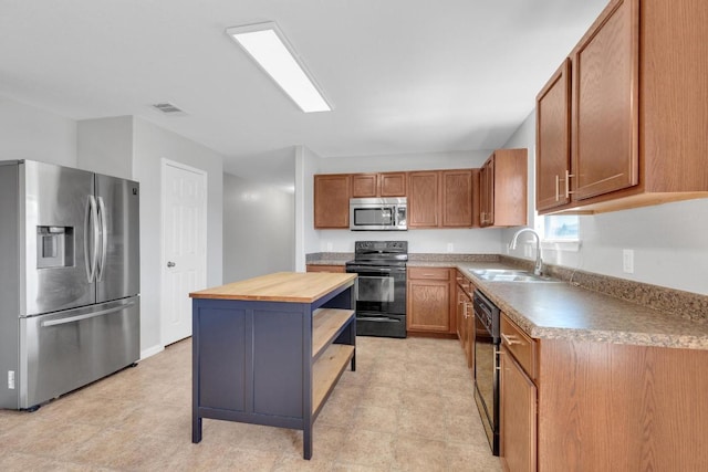 kitchen with visible vents, a sink, wooden counters, black appliances, and open shelves