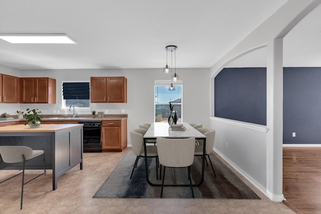 kitchen with dishwasher, hanging light fixtures, baseboards, and brown cabinets